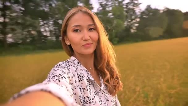 Красиві азіатські жінки крутяться на пшеничному полі влітку — стокове відео