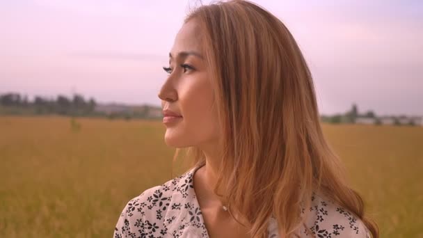 Portret van mooie Aziatische vrouw op graan veld op zonsondergang genieten van natuur — Stockvideo