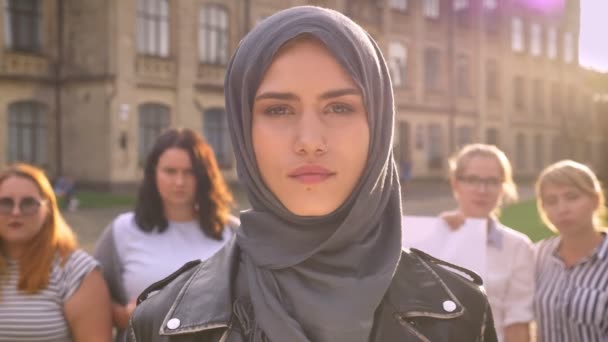 Kaukasische meisje in hijab nauw kijken met vertrouwen naast handelend feministische parade — Stockvideo