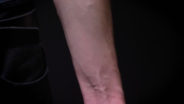 Strained fist and muscular hand of caucasian sportsman on black background in studio — Stock Video