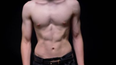 Studio koyu arka plan üzerinde vücut kamera yürüyüş ve onun gösteren sportif üstsüz beyaz adam uygun