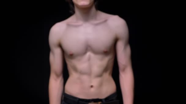 Sporty topless caucasian man walking in camera and demonstrating his fit body on dark background in studio — Stock Video