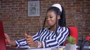 Afrikalı güzel kız dans tuğla Studio çalışma masasında otururken rahatlatıcı geçiriyor