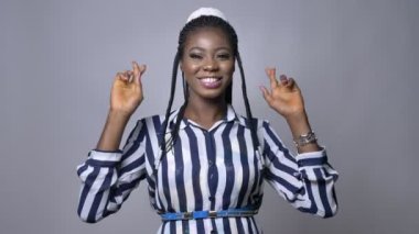 gri arka plan üzerinde parmaklarını şans getirsin diye kameraya geçiş oldukça Afrikalı kadın