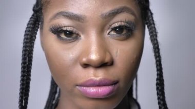 yakın çekim fotoğraf makinesi ile gurur ve güven gri folyo üzerinde bakarak güzel Afrikalı kız portresi