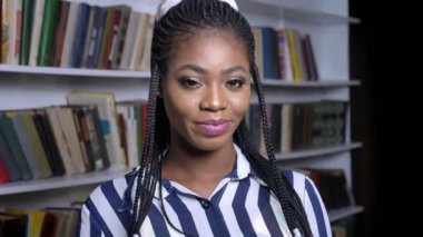 hala ayakta ve Kütüphane sakin ve rahat kamerada bakarak muhteşem Afrikalı kız