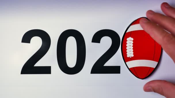 Ilustración, año nuevo, mano masculina puesta sobre la mesa en pelota de fútbol, 2020 — Vídeos de Stock