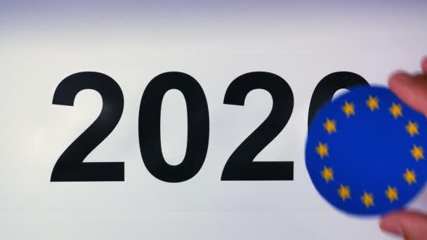 Illustrazione, anno nuovo, mano maschile messa sul tavolo sulla bandiera dell'Unione europea, palla di paese, 2020 — Video Stock