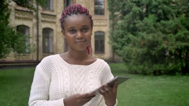 Unga Afroamerikanska Kvinnan Vit Tröja Holding Tablett Och Ler Mot — Stockvideo