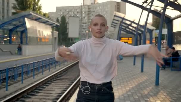 Incrível jovem careca caucasiano fêmea está dançando livremente na estação de trem durante o dia — Vídeo de Stock