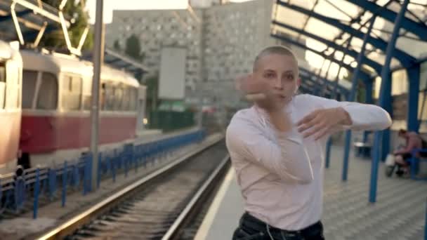 Üzgün kel beyaz kız kendini Tren İstasyonu, dans ve sonunda asfalt üzerinde gündüz döşeme üzerinde express — Stok video
