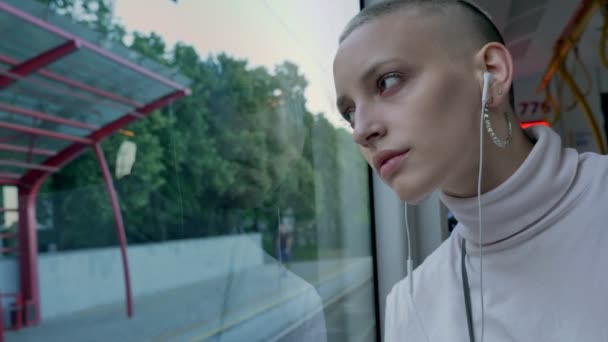 在火车, 城市图片和放松心情的窗口附近的年轻秃头白人妇女的开放外观 — 图库视频影像