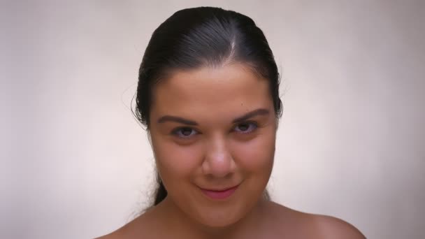 Selbstbewusstes Aussehen und entspannte Stimmung einer nackten kaukasischen Frau mit sauberer Haut im hellen Studio — Stockvideo