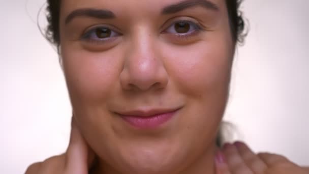 Close-up portret van overgewicht leuk Kaukasische meisje met perfecte gloeiende huid en glad gezicht op wit — Stockvideo
