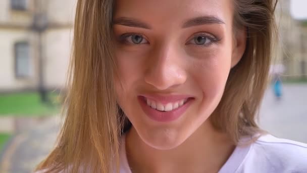 Skrattande trevliga kaukasiska kvinnliga titta rakt på kameran med uppriktigt leende utomhus, solig dag — Stockvideo