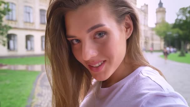 Calme regarder caméra caucasienne fille en mouvement, concentré en face de caméra sur la rue seul — Video