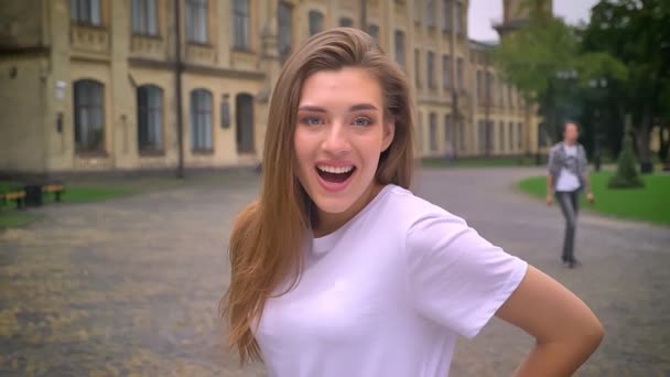 Femeie caucaziană frumoasă cu păr lung se uită la camera foto cu o mare surpriză în mișcare în afara — Videoclip de stoc