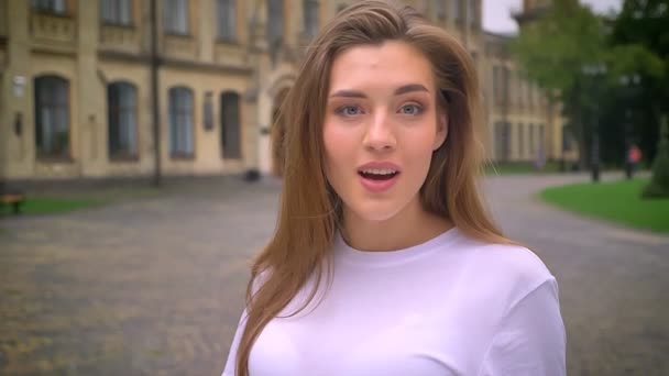 Surprise folle de magnifique fille caucasienne, debout dans la rue sur fond de rue — Video