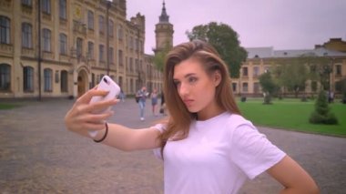 binaların dışında muhteşem beyaz kadın alarak selfie telefonunu sokakta duran ile rahat