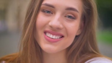 dışında yakın çekim portre sarışın güzel beyaz erkek, düz bakın kamera ve eğlenceli gülümsemek,