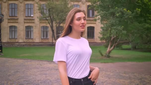 Wandelen mooie Kaukasische blond meisje, vol vertrouwen op zoek, het oversteken van de straat, stedelijke sfeer, beweging, overdag — Stockvideo