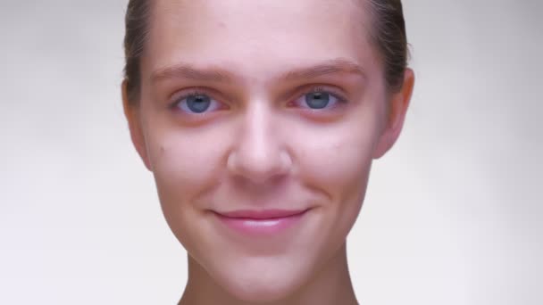 Unwinking stare van mooie Kaukasische vrouw met mooie schone huid in witte studio — Stockvideo