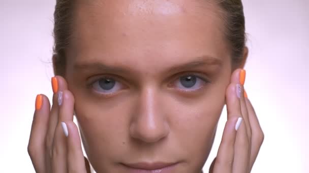 Ruhigen Blick in die Kamera und sanfte Berührung von gesundem frischem Gesicht von kaukasischen Frau, Nahaufnahme, im weißen Studio — Stockvideo
