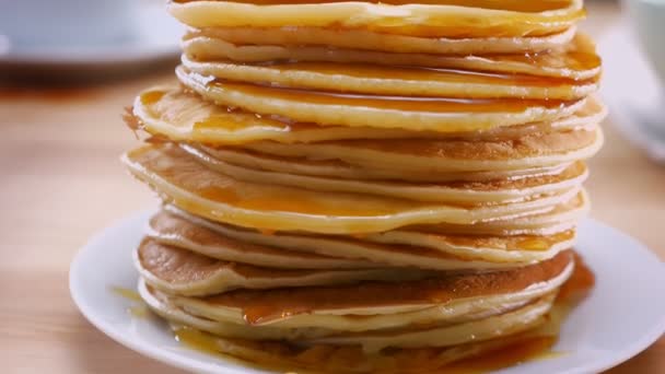 Perfecte zonnige huisgemaakte pannenkoeken op de plaat zijn bedekt met vloeibare honing, huisgemaakte maaltijd — Stockvideo