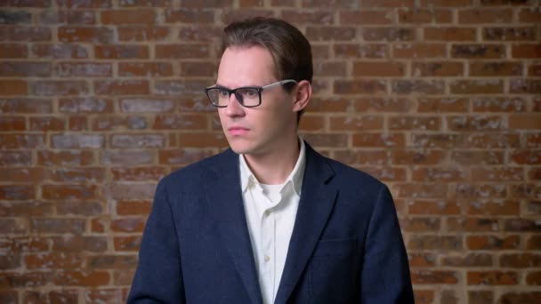 Bingo kaukázusi Férfi sötét öltöny, szemüveg, office megjelenése, tégla háttér állandó jele — Stock videók