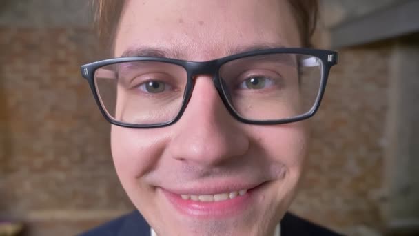 Közeli boldog mosolygó arc a kaukázusi Férfi szemüveg, közvetlen megjelenés és elégedett személy, beltéri — Stock videók