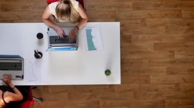 «Ana sayfa» shot, rahat çalışma ruh hali, telefon ile mavi perde, beyaz ortak masada kapalı otururken kontrol tipik üstünde smartphones, iki kız