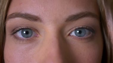 Yakın çekim güzel büyük mavi gözleri beyaz kadın yanıp sönmediğinden kameraya bakıyor ve odaklanmış
