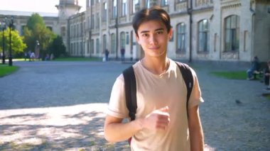 Güzel Asyalı çocuk gösteren düz boş sokakta duran bir jest gibi çevreleyen görünüm güneş parlıyor