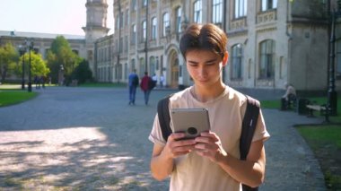 Konsantre güzel Asyalı çocuk onun tablet duran eski şaşırtıcı City, spot renkleri yaz havasında güneş ışığı kullanma