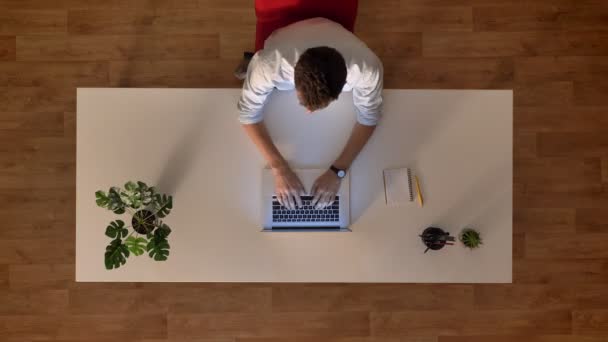 Top-down shot time lapse hane i trä office använder laptop när du sitter vid skrivbord, dag start och mål — Stockvideo