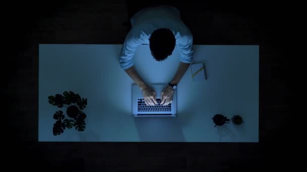 Top shot time-lapse passeren tijd in office vibes, man aan het typen is op de laptop en urenlang werken binnen, spel van licht — Stockvideo