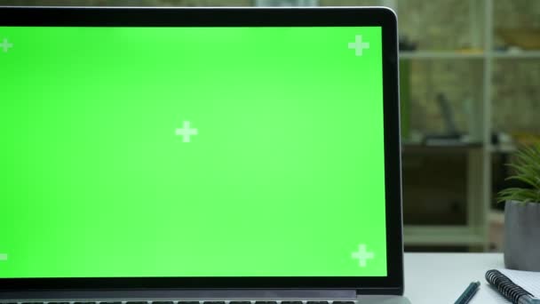 Зелений екран ноутбука в сучасному офісі, крупним планом, робочий комп'ютер, порожній простір в приміщенні — стокове відео