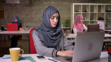 Güzel Arap kadın güzel hijab onu laptop, yazarak gri ayrılmış arkasında, diğer Müslüman kızlardan modern yaşam tarzı