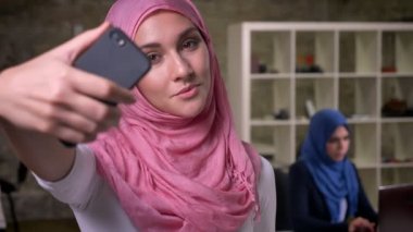 Pembe hijab tuğla modern ofis onun çalışma meslektaşlarından izole fotoğraf çekmek Arapça kadın güzel odaklı yüzü