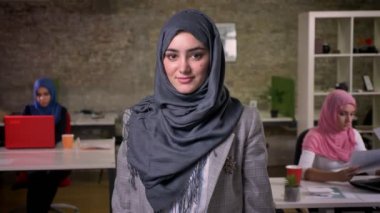 Gri hijab güzel Arap kızı kameraya düz, arka plan, modern gerçeklik vibes Arap kızlar ayakta iken soğuk bakıyor
