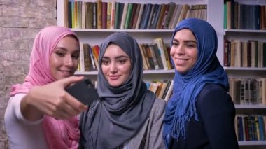 Üç güzel hijab Müslüman kadın resimleri ve selfie duran kapalı, telefon ile alıyor arka plan, mutlu ruh hali üzerinde kitaplar