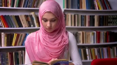 Pembe hijab mutlu Arap kadın duruyor Kütüphane ve neşeli gülümseyen, Ortadoğu ruh hali, sakin yer