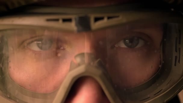 Close-up eyes of caucasian soldier on helmet and camouflage looking straight at camera, calmly, persistent look, power illustration — Stock Video