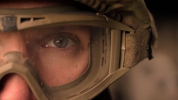 Крупным планом сфокусирован глаз сильного военного в форме и шлеме, смотрящего в камеру, стоя, подлинный современный внешний вид — стоковое видео
