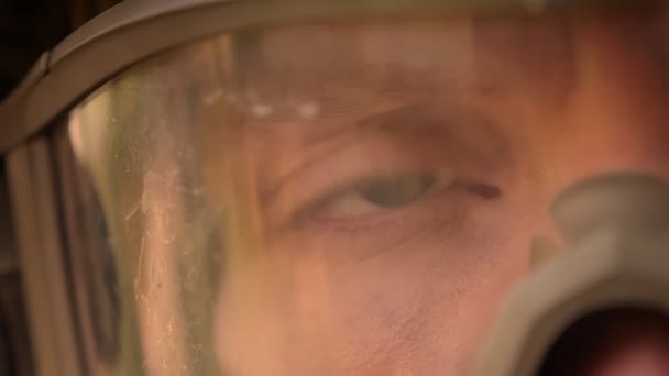 Крупным планом моргающий глаз кавказского солдата в маске, отражение солнечных лучей, спокойный и уверенный в себе храбрый человек — стоковое видео