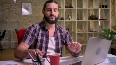 Alt arka plan üzerinde ışık modern ofisindeki izole hassas göz oturan beyaz güzel sakallı erkek, rahat tarzı, ekran