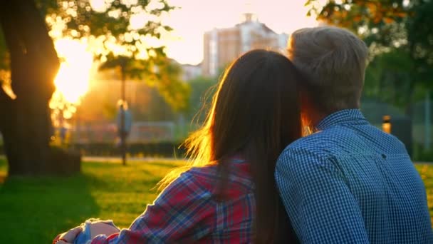 Dos personas encantadoras en el amor están sentados de cerca en el increíble parque de verano, el sol brilla en todas partes jucy vista, hermosa relación — Vídeos de Stock