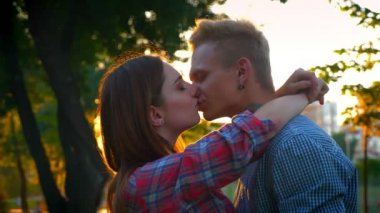 Güzel çift sakince öpüşme güzel pakk açık duran, sunlights, rahat bakmak