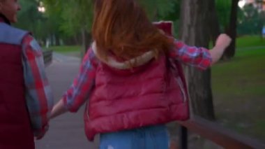 Hoş mutlu adam çalıştıran ve onu geri dönüş önde gelen kız elini tutarak ve güzel gülümsüyor, park ve yeşil her yerde, güzel yaz ruh çim