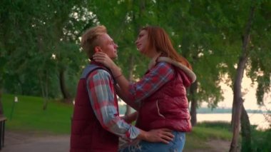 Güzel kız oturuyor çit erkek arkadaşı onu şefkatle, tutan iken dolu aşk Fransa, benzersiz an, park view ve yaz vibes
